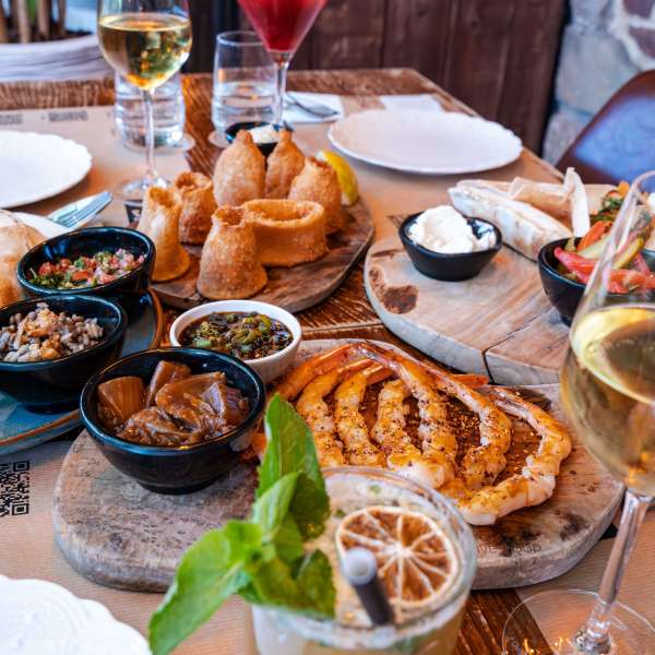 Tapas à partager au resto Les Granges. Calmar, crevettes, etc. Vins et cocktails sur une belle table.
