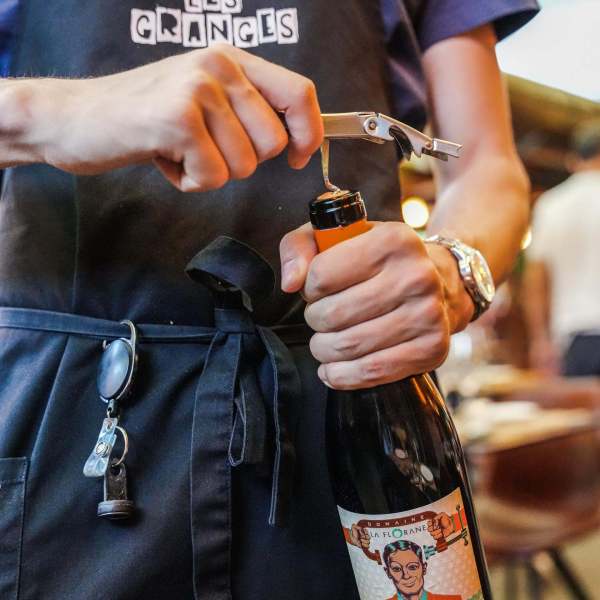 Serveur des Granges en train d'ouvrir une bouteille de vin Je ne souffre plus.